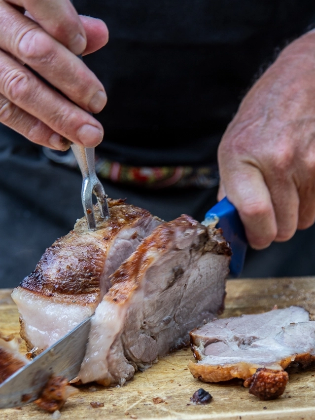 Schweinsbraten wird aufgeschnitten